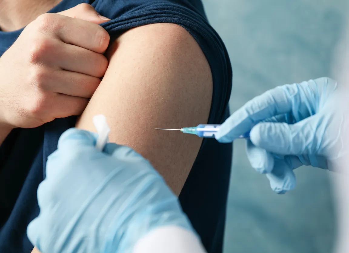 Focus on arm of patient receiving a vaccine