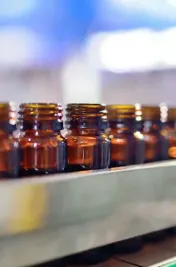 Pharmaceutical glassware on conveyor belt to filling and capping machine
