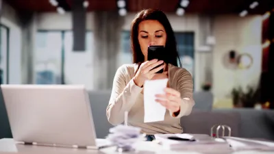 Woman taking a photo of a receipt with her phone.