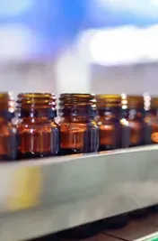 Pharmaceutical glassware on conveyor belt to filling and capping machine